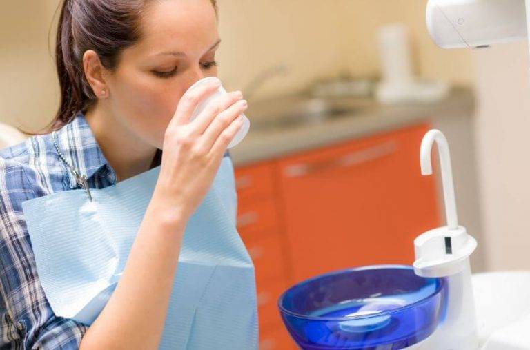 dental patient using mouth wash after teeth cleaning